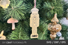 Load image into Gallery viewer, Wooden nutcracker ornament with 'Zander' on a Christmas tree with other ornaments.