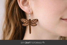 Load image into Gallery viewer, Dragonfly-shaped earring worn by a person with a blurred background
